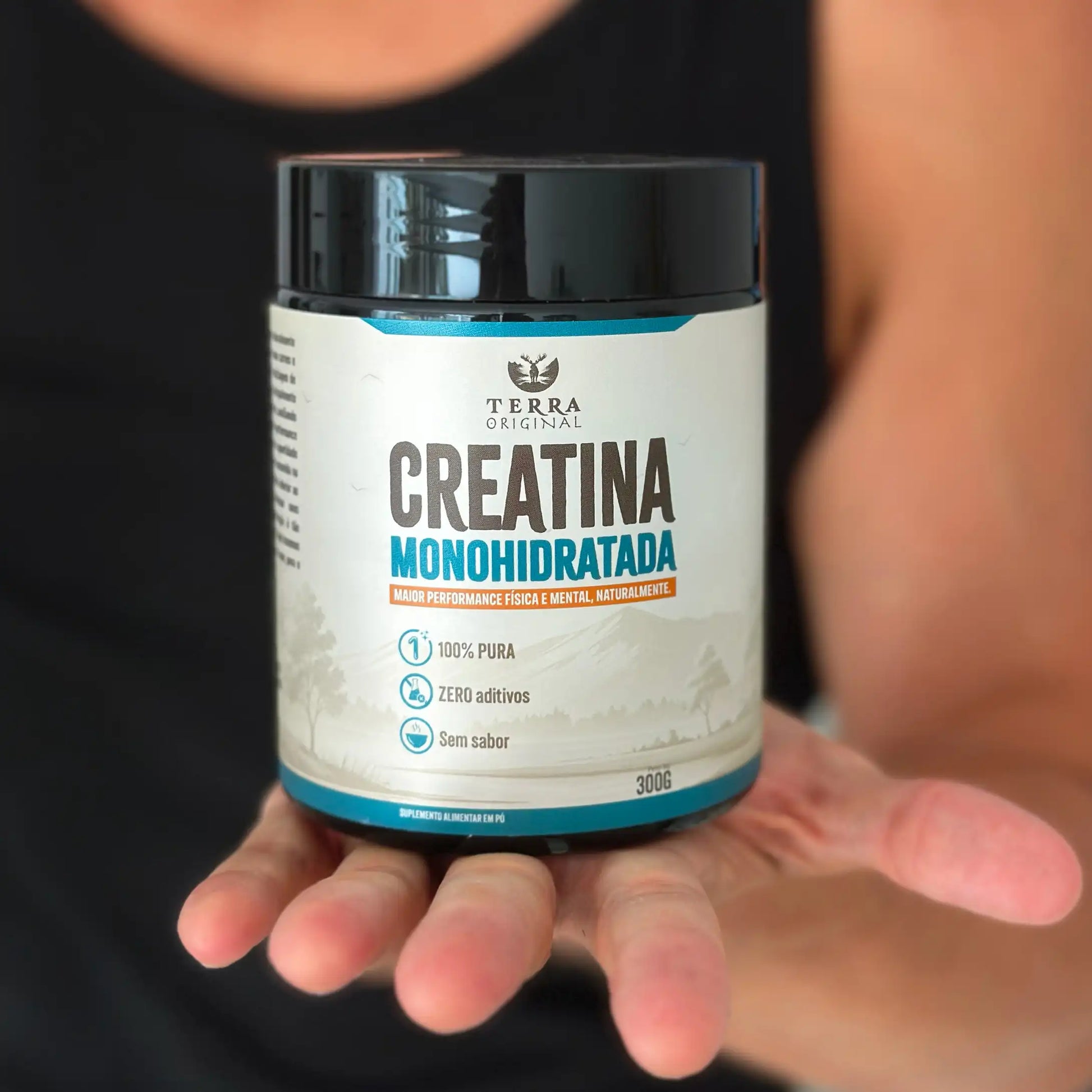 Pessoa segurando pote de creatina monohidratada 100% pura e sem aditivos Terra Original com rótulo frontal em destaque